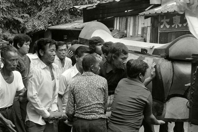 Carrying the traditional 'three-humped' Chinese coffin of the Lau Chet Kee Hoon Teochew opera boss into the hearse at the start of funeral procession