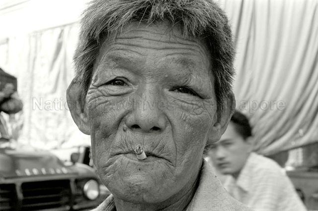Chinese man with weather-beaten face along Clarke Quay