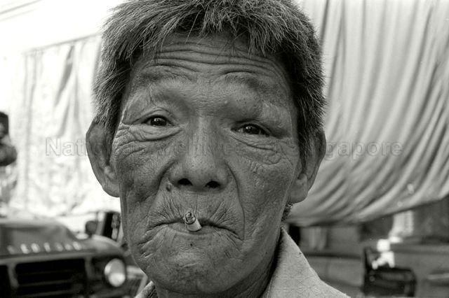 Chinese man with weather-beaten face along Clarke Quay