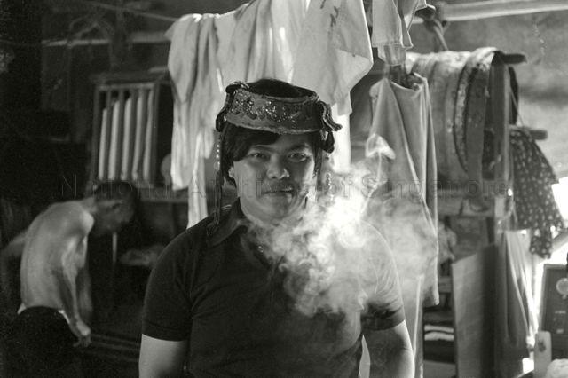 Man exhaling smoke from cigarette at backstage of a Chinese street opera