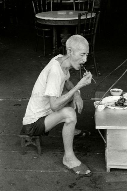 Eating satay from a street hawker along Clarke Quay