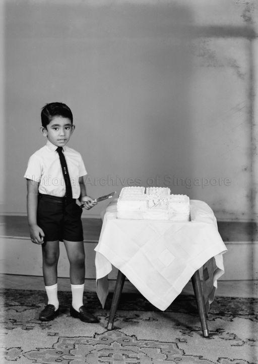 Full length portrait of boy with birthday cake