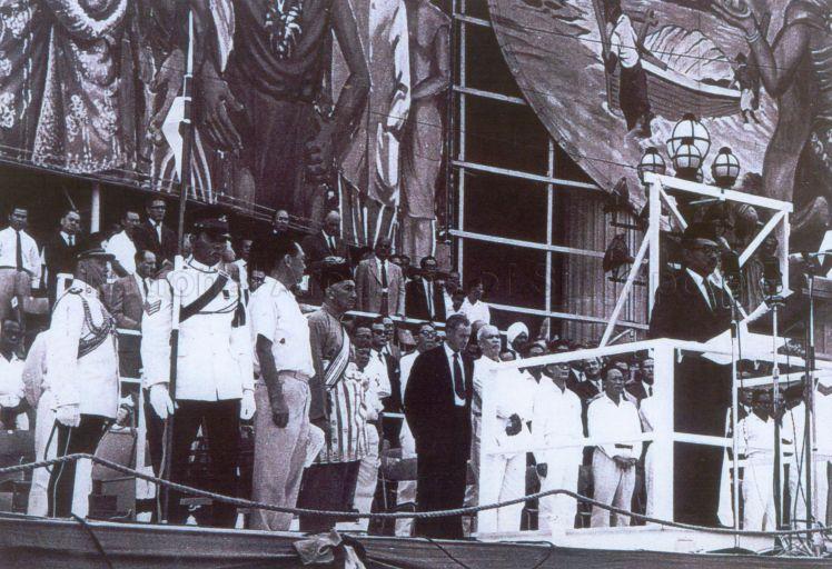 Photo shows the Malaysia Proclamation ceremony held at City Hall, Singapore at about 5pm. Similar ceremonies were also held in Kuala Lumpur, Kota Kinabalu (Sabah) and Kuching (Sarawak) but at different timings. Present at the ceremony in Singapore were the Yang Di-Pertuan negara, Yusof Bin Ishak, the Prime Minister of Singapore, Mr Lee Kuan Yew; the British Secretary for Commonwealth Relations, Mr Duncan Sandys, the Federation Minister for Internal Security, Dr Ismail Bin Abdul Rahman along with Singapore government ministers and members of the Judiciary and Consular Corps. &nbsp;On the rostrum, Dr Ismail was reading a message on behalf of the Federation Prime Minister, Tunku Abdul Rahman, "We have made our decision after much care and thought....this spirit of co-operation and concord is living proof of the desire we share for a common destiny....". The ceremony was held to officially proclaim the formation of Malaysia, constituting Singapore, Malaya, Sabah and Sarawak.
