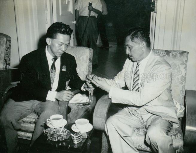 Tan Howe Liang, silver medalist for weight-lifting at the 1960 Olympic Games in Rome, showing Yang Di-Pertuan Negara Yusof Ishak the medal during tea party at the Istana Negara