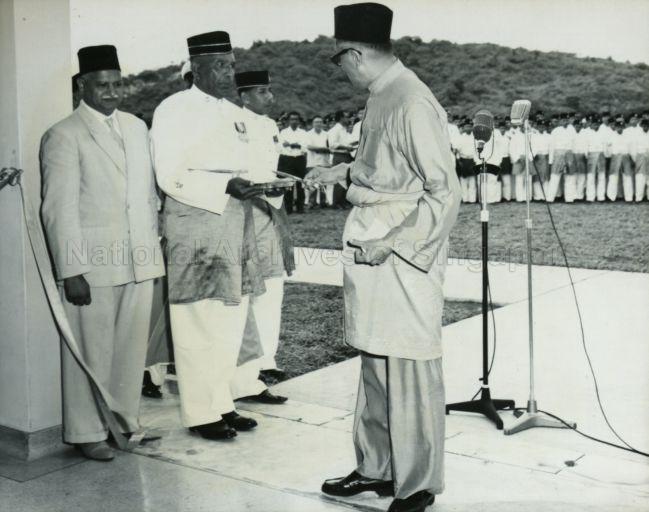 Yang Di-Pertuan Negara Yusof Ishak replacing scissors on the tray after cutting ribbon to declare open the Masjid Tentera Di-Raja (Military Mosque) at Clementi Road