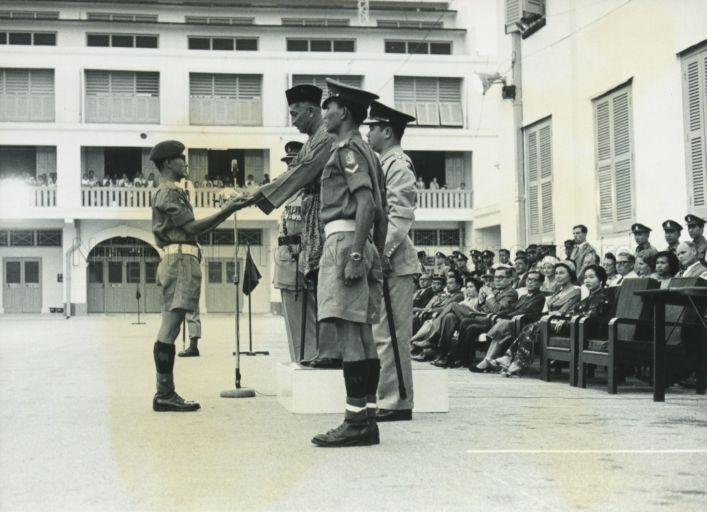 Yang Di-Pertuan Negara Yusof Ishak presenting the Sword of Honour to the best officer cadet at passing-out parade for Officer Cadets at the Singapore Military Forces' Headquarters at Beach Road