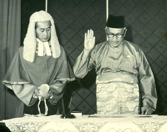 Yang Di-Pertuan Negara Yusof Ishak taking the oath of office on his re-appointment as Yang Di-Pertuan Negara, watched by Chief Justice Wee Chong Jin