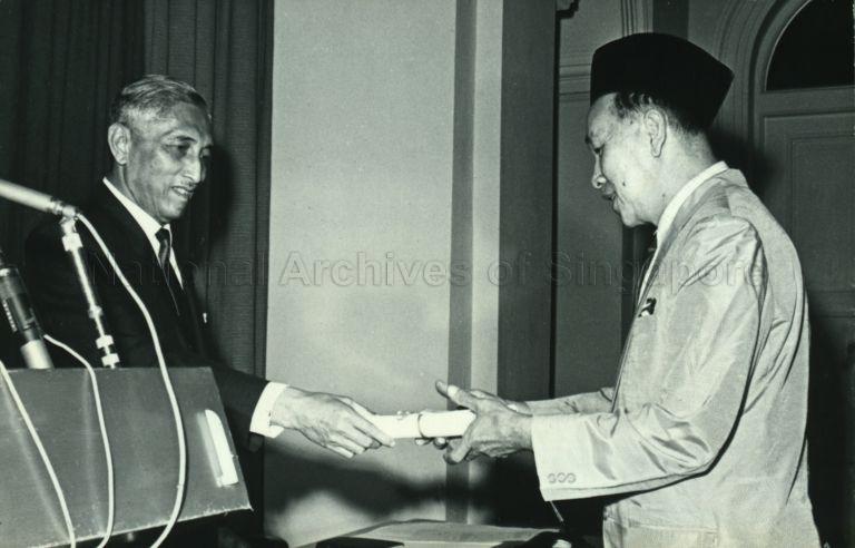President Yusof Ishak presenting Ismail Bin Abdul Aziz, president of the Muslim Religious Council, with letter of appointment as member of the newly-formed Presidential Council at the Istana