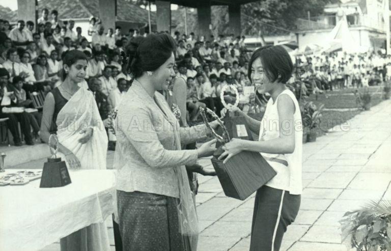 Puan Noor Aishah presenting trophies to winners at the Singapore Amateur Athletics Association Championship at Farrer Park