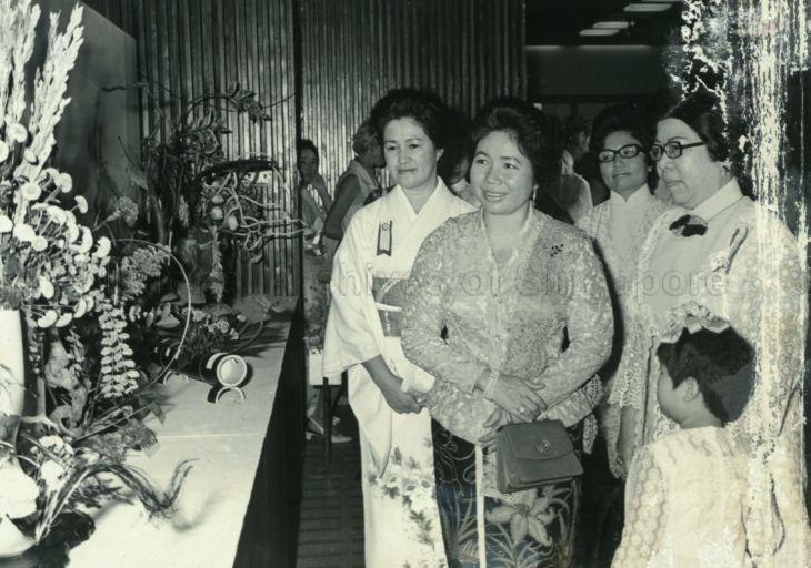 Puan Noor Aishah being shown round the Singapore Sogetsu Association's fifth annual floral exhibition at Singapore Conference Hall by Mrs Kazue Kim, head of the Sogetsu School here and flower arrangement expert, (in kimono) and Datin Lee Chee Sang, chairman of organising committee (right). The exhibition, opened by Puan Noor, was in aid of the Singapore Association for the Blind and St Andrew's Mission Hospital.