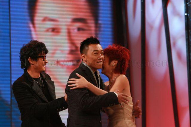 MediaCorp TV artiste Guo Liang (centre) being congratulated by Quan Yifeng after winning the "Best Variety Show Host" award during Star Awards at MediaCorp TV Theatre, Caldecott Hill. Looking on is MediaCorp TV artiste Christopher Lee (left).
