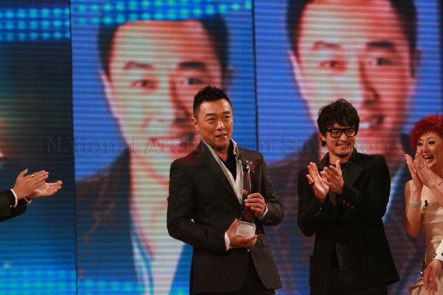 MediaCorp TV artiste Guo Liang (left) after winning "Best Variety Show Host" award during Star Awards at MediaCorp TV Theatre, Caldecott Hill. Looking on from right are MediaCorp TV artistes Quan Yifeng and Christopher Lee.