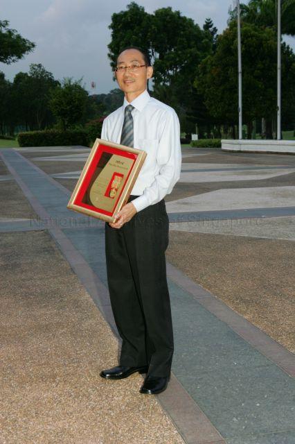 Michael Chang Seng Chew holding the Comrade of Labour (Star) award which he received during May Day Dinner at Orchid Country Club