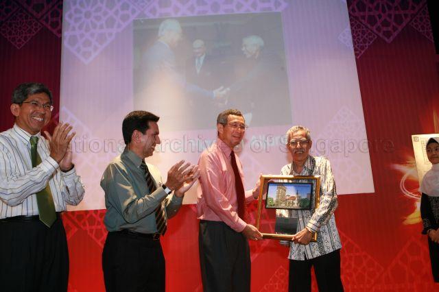 Prime Minister Lee Hsien Loong presenting Islamic Religious Council of Singapore (MUIS) 40th anniversary award to pioneer MUIS leader during 40th anniversary celebrations of MUIS at auditorium of Singapore Islamic Hub in Braddell Road. On the left are Minister for the Environment and Water Resources and Minister-in-charge of Muslim Affairs Associate Professor Dr Yaacob Ibrahim and MUIS President Alami Musa.