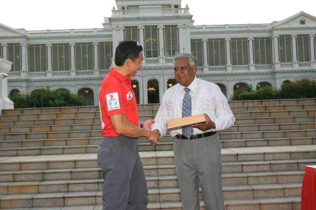 President S R Nathan presenting token of congratulations to coach of Singapore Women's Everest team Lim Kim Boon at Istana Lawn during reception held in honour of the women Everest climbers