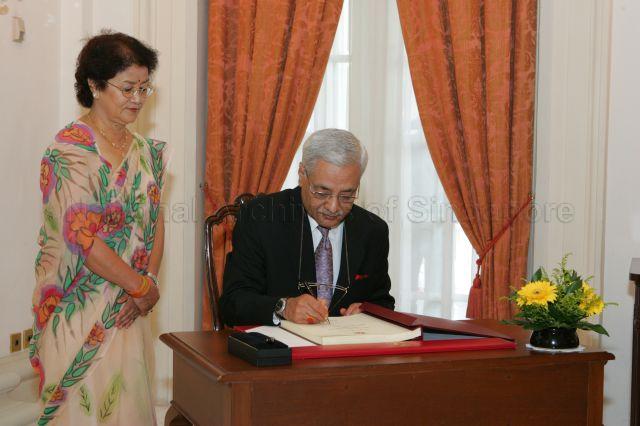 Ambassador-designate of Nepal to Singapore Naveen Prakash Jung Shah signing guest book when he arrives at Istana main building to present his credentials to President S R Nathan. Looking on is his wife.