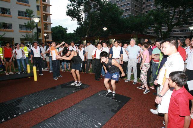 Minister Mentor Lee Kuan Yew watching standing broad jump demonstration during walkabout in Henderson Heights at Tanjong Pagar Group Representation Constituency (GRC)'s tree planting day