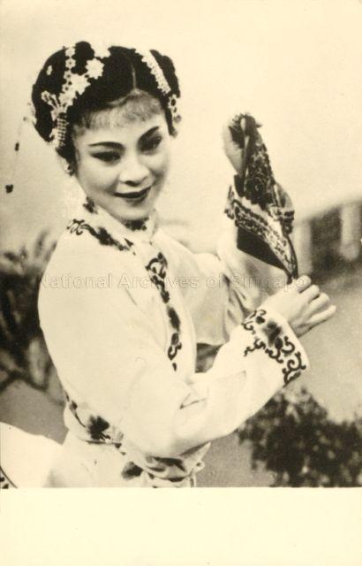 Scene from a Teochew film adapted from a popular Chinese opera "Tan Sah Ngoh Neo" (Hokkien) or "Chen San Wu Niang" (Mandarin) where the maid changes to a different costume and shows the gentle side of her personality. In a previous scene she was dressed in dark working clothes. In Chinese society, to highlight feminity, it is important to observe the position of the fingers and the way the handkerchief is used.