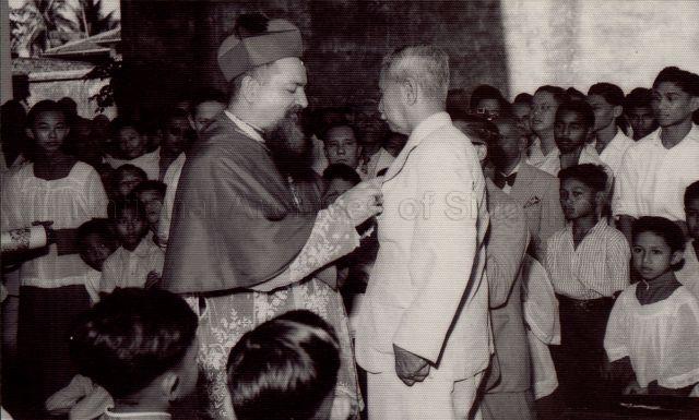 William Fairley Scully (Bill) receiving the Bene Merenti, a Papal Award, on 20 May 1951, for his services to the Church. His Grace the Archbishop, Michael Olcemendy is pinning the medal to his lapel at the Church of the Holy Family in Chapel Road. Bill was very proud of the medal and would pin it on his jacket to Church every Sunday.