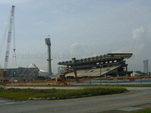 Demolition of the National Stadium in progress. Some spectator seating sections have been completely torn down, with the grandstand and the floodlight tower remaining. The National Stadium was officially closed on 30 June 2007 and the demolition process was started on 29 September 2010 to make way for the new Singapore Sports Hub.