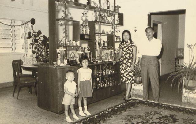 Mrs Helen Wong Kwok Leong nee Mah Jia Lan with her husband Wong Kwok Leong and children. The bowling trophies that she has won over the years are displayed on the cupboard beside her.