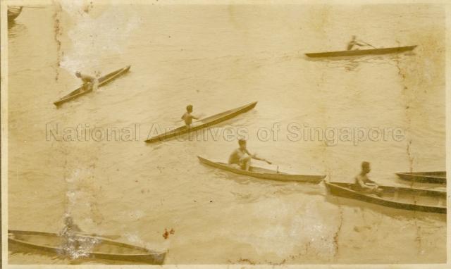 Malay boys rowing small boats