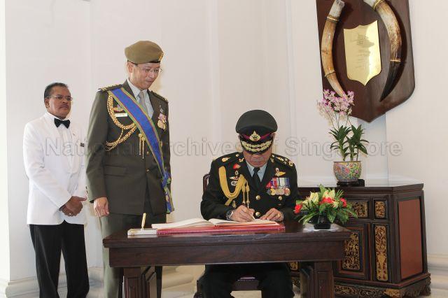 Royal Thai Armed Forces (RTARF) Chief of Defence Forces General Songkitti Jaggabatara signing guest book when he arrives at Istana to receive Distinguished Service Order (Military) from President S R Nathan. Looking on is Singapore Chief of Defence Force Lieutenant General Neo Kian Hong.