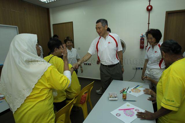 Prime Minister Lee Hsien Loong shaking hands with senior citizens while touring Community Care Network Senior Activity Centre (CCNSAC) at Block 420, Ang Mo Kio Avenue 10, during opening of CCN community fair for senior citizens and launch of the activity centre. On the right is Member of Parliament for Ang Mo Kio Group Representation Constituency (GRC) Lee Bee Wah.