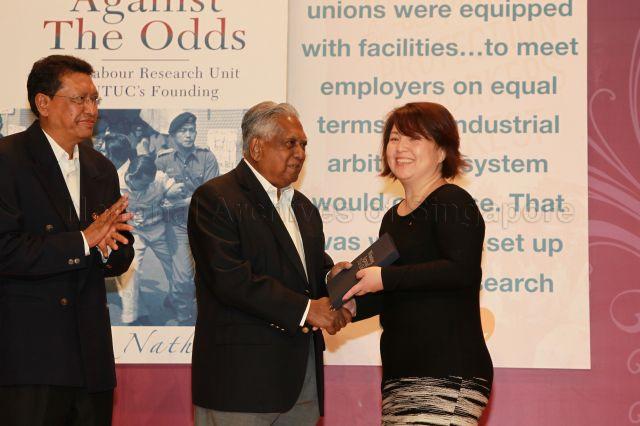 President S R Nathan presenting copy of his book "Winning Against the Odds - The Labour Research Unit in NTUC's Founding" to guest during the book launch at National Trades Union Congress (NTUC) Centre auditorium. Looking on is NTUC President John De Payva.