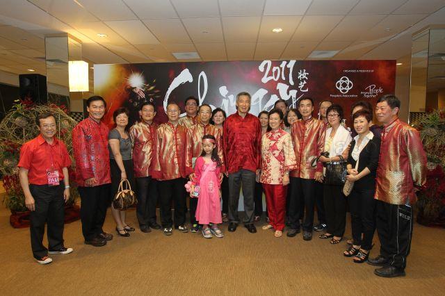 Prime Minister Lee Hsien Loong and his wife, Madam Ho Ching, posing for photographs with participants and guests at post-parade reception during opening night of Chingay parade 2011 held at F1 Pit Building, Marina Bay. Also in the picture is Chief Executive Director of People's Association Yam Ah Mee (second from left).
