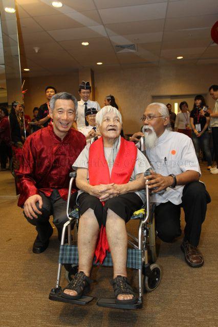 Prime Minister Lee Hsien Loong posing for photographs with 113-year-old social worker Ms Teresa Hsu, who is also founder of Heart to Heart Service, and her co-worker Sharana Rao at post-parade reception during opening night of Chingay parade 2011 held at F1 Pit Building, Marina Bay