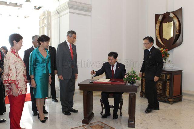 Mongolian Prime Minister Sukhbaatar Batbold, who is on a two-day official visit to Singapore, signing guest book at Istana after the ceremonial welcome. Among those looking on are Prime Minister Lee Hsien Loong, Madam Khorloo Otgontuya and Madam Ho Ching. 