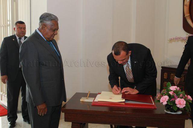 Honduran President Porfirio Lobo Sosa signing guest book when he calls on President S R Nathan at Istana