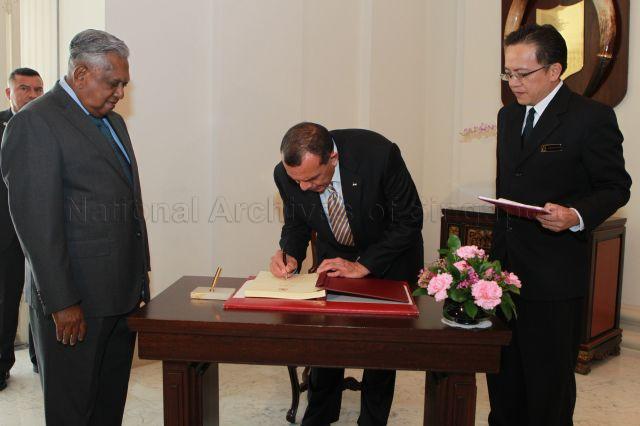 Honduran President Porfirio Lobo Sosa signing guest book when he calls on President S R Nathan at Istana