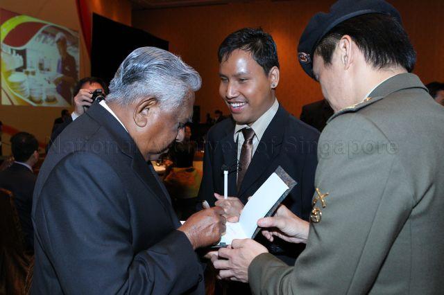 President S R Nathan signing an autograph during the inaugural Enabling Employers Awards dinner held at Marina Bay Sands Grand Ballroom