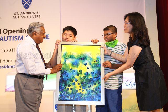 President S R Nathan receiving a painting by Joshua Ten and Saviour Moses, both students of the autism school, during official opening of new premises of St Andrew's Autism Centre at No. 1 Elliot Road