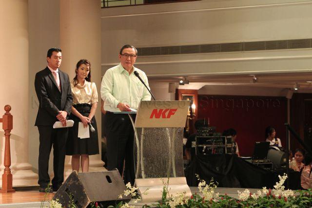 Chairman of National Kidney Foundation (NKF) Gerard Ee speaking at NKF's 100-table charity dinner held at Grand Ballroom, Orchid Country Club. Behind him are Channel NewsAsia presenters Nicholas Fang and Ms Suzanne Jung, the masters of ceremonies for the event.
