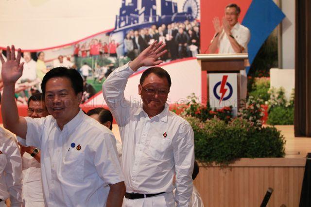 Mr Ong Kian Min (left) and Mr Eric Low Siak Meng, who will retire in the forthcoming general election, waving to the audience during 25th Anniversary Rally of Young People's Action Party (YP) at NTUC Centre auditorium in Marina Boulevard