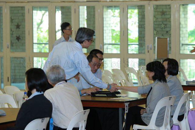 General Election 2011 - Workers' Party (WP) candidates for Aljunied Group Representation Constituency (GRC) Chen Show Mao (standing), Low Thia Kiang and Pritam Singh (partially hidden) at Deyi Secondary School in Ang Mo Kio Street 42, the nomination centre for electoral divisions of Ang Mo Kio, Aljunied, Bishan-Toa Payoh and Sengkang West
