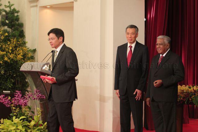 Minister of State for Education and Defence Lawrence Wong bowing to the audience after receiving the instrument of appointment from President S R Nathan, during the swearing-in ceremony at Istana. Also looking on is Prime Minister Lee Hsien Loong.