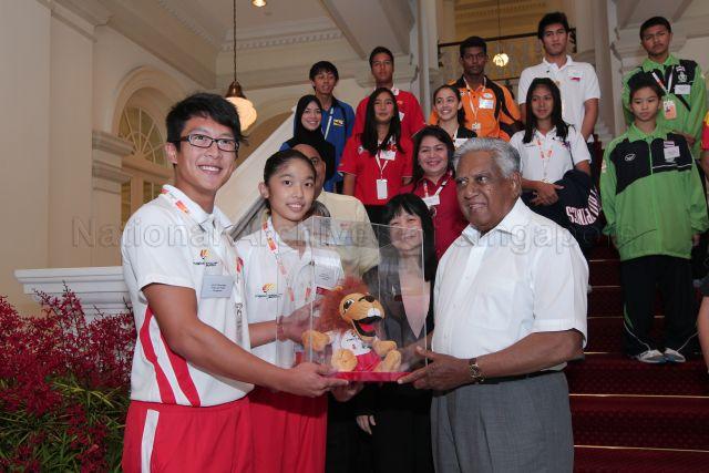 Singapore's men vault star Sean Lim and gymnast Phaan Yilin presenting a plush toy of ASEAN Schools Games' mascot named Sean the Lion to President S R Nathan during courtesy call by athletes and officials from seven participating nations of the Games at Istana