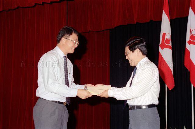 People's Association Youth Movement Flag Day Cheque Presentation Ceremony at People's Association Auditorium - People's Association presenting cheques on stage.