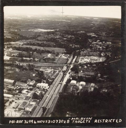 Aerial view of Bukit Timah, central western part of Singapore. Photograph shows truss bridge (centre) and tracks for nearby Bukit Timah Railway Station spanning across the parallel Bukit Timah Road and Dunearn Road, with Yeo Hiap Seng Sauce Factory on right side of the bridge and King Albert Park on the left.
