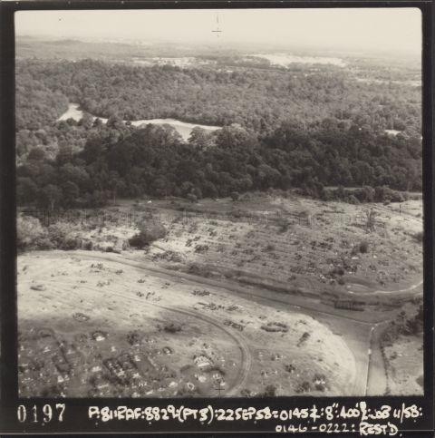 View looking somewhat northwards. The photograph shows Bukit Brown in the lower forefront (the 2 mounds/hills), with MacRitchie Reservoir and the Central Catchment Forest in the upper background. The lower mound/hill in Bukit Brown is likely Block 2 of the cemetery, and the upper mound/hill with its back to the Reservoir is part of Block 4 of the cemetery.