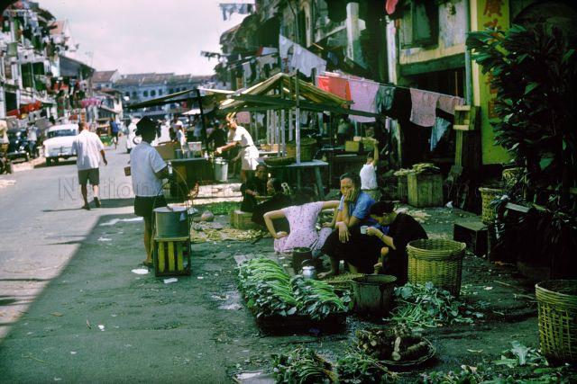 Chinatown, Singapore. Upper Chin Chew Street (Beancurd Street-è±†è…è¡—) looking from after South Bridge Road toward New Bridge Road. Hawkers selling groceries on the road.
