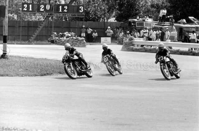 Looi Im Heok on a Norton (number 50) is followed by Bulldog Kuan on a Norton (number 61) and Lim Meng Cheng on a Norton (number 73) during third Malaysia Grand Prix (also known as Malaysian Grand Prix) held at Upper Thomson Road, Singapore. Looi is the owner of Looi's Motor, a motorcycle shop situated at Upper Thomson Road (now at Kaki Bukit Place) and is the father of Tommy Fang and uncle to Gerry Looi and Looi Beng Hoe, all top motorcycle racers.