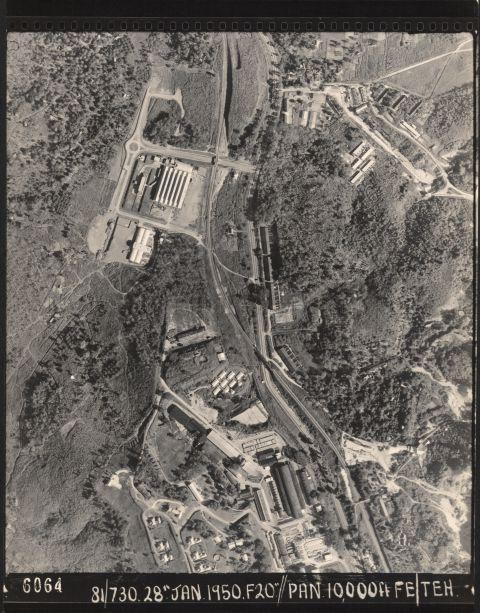 Nine milestone Bukit Timah Road (Upper Bukit Timah Road) where the KTM railway or Malayan Railway line crosses the truss bridge. Top right is Public Works Department (PWD) quarry (present site of Dairy Farm Nature Park). The serrated roof building on the left is National Carbon Ltd (later known as Union Carbide), maker of Eveready batteries. Beside it to the south is Malayan Gutta Ltd, manufacturer of Wrigley Chewing Gum. The massive factory at the bottom of the picture is Hume Industries with Singapore Quarry (formerly known as Chia Eng Say Quarry) in the bottom right corner.