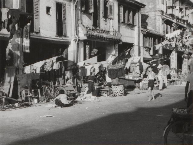 Clothes hung out to dry on bamboo poles above street vendors in Chinatown
