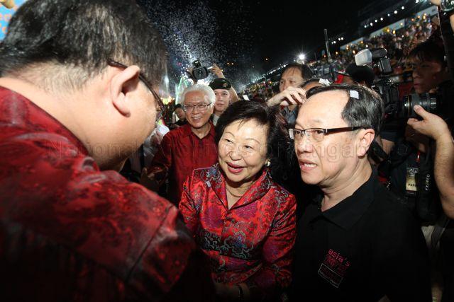Chairman of the Chingay Parade Exco Mr Nah Juay Hng escorting President Tony Tan and Mrs Mary Tan through the crowds as they thank the performers at the end of Chingay parade 2013.