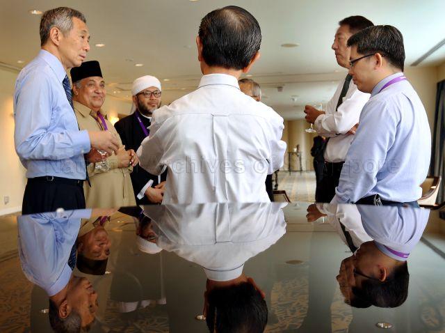 Prime Minister Lee Hsien Loong, the two Co-Chairmen of Religious Rehabilitation Group (RRG) Ustaz Ali Haji Mohamed (with songkok) and Ustaz Mohamad Hasbi Hassan and Deputy Prime Minister and Coordinating Minister for National Security and Minister for Home Affairs Teo Chee Hean at the reception during International Conference on Terrorist Rehabilitation and Community Resilience organised in conjunction with RRG's 10th anniversary at Raffles City Convention Centre